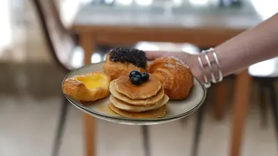 a person holding a plate of pastries on a plate at Hotel Lepelbed in Ghent