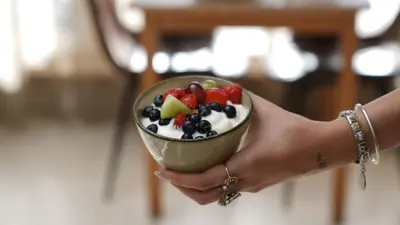 a person holding a bowl of fruit salad at Hotel Lepelbed in Ghent
