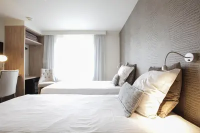 a hotel room with two beds and a window at Hotel Lepelbed in Ghent