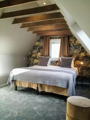 a bedroom with a large bed in a attic at Hotel Lepelbed in Ghent