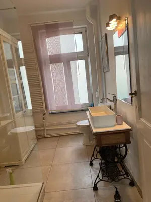 a bathroom with a sink and a toilet and a window at Rétro Studio in Brussels