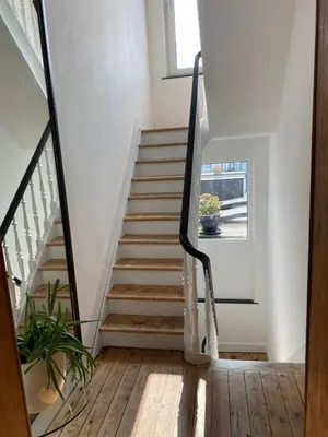 a staircase in a home with white walls and wooden floors at Rétro Studio in Brussels