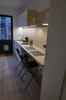 a kitchen with a counter and chairs in a room at Margaretha's Room in Mechelen