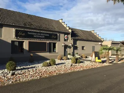 a building with a sign on the side of a street at Vakantiehuisje De Waterhoek in Geel