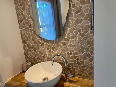 a bathroom with a sink and a mirror at Vakantiehuisje De Waterhoek in Geel