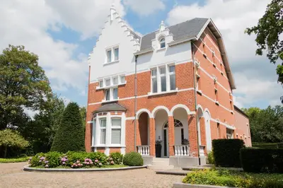 a large red brick building with a white turret at Prachtig herenhuis uit 1925 in Nijlen