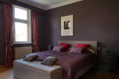 a bedroom with a large bed with red pillows at Prachtig herenhuis uit 1925 in Nijlen
