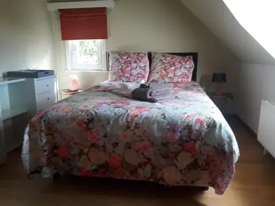 a bedroom with a bed with a floral comforter at Prachtig herenhuis uit 1925 in Nijlen