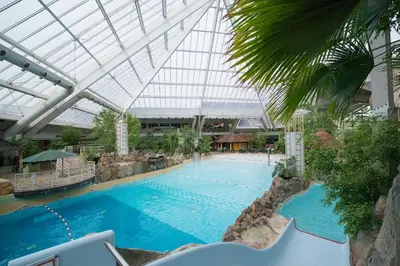 a large swimming pool in a building with a ceiling at Hotel Kempense Meren by Sunparks in Mol