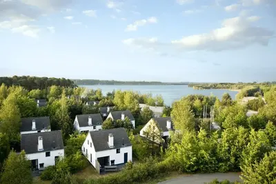 an aerial view of a village with houses and a lake at Hotel Kempense Meren by Sunparks in Mol