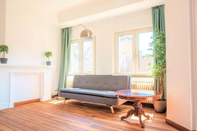 a living room with a couch and a table at Penth A Apartment in Heart of Antwerp in Antwerp