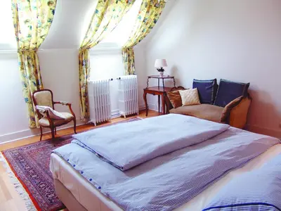 a bedroom with a bed and a chair and a window at Louise Chatelain suites in Brussels