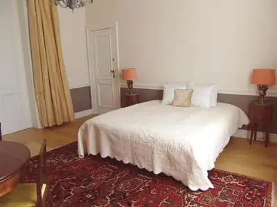 a bedroom with a white bed with two lamps and a table at Louise Chatelain suites in Brussels