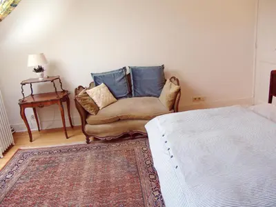 a bedroom with a couch and a bed and a table at Louise Chatelain suites in Brussels