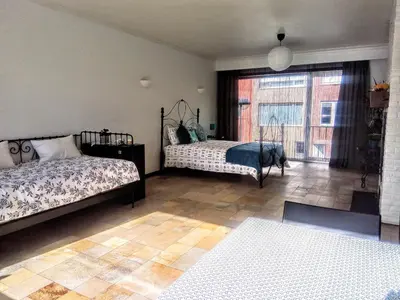 a bedroom with two beds and a large window at Harmony House in Antwerp