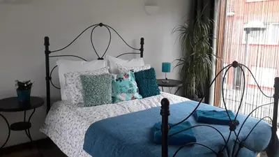 a bedroom with a bed with a blue blanket and pillows at Harmony House in Antwerp