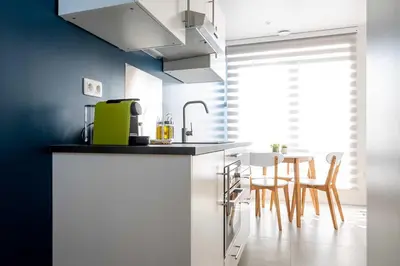 a kitchen with a counter and a table with chairs at Studio Brussels Airport - North in Zaventem