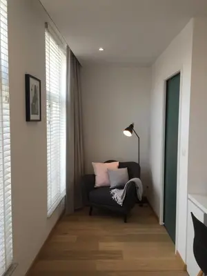 a living room with a chair and a lamp at Antwerp Town House Accommodations in Antwerp