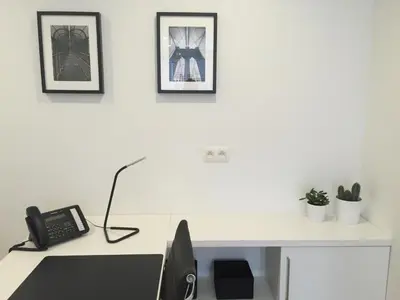 a white desk with a phone and pictures on the wall at Antwerp Town House Accommodations in Antwerp