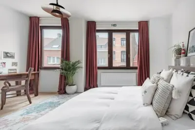 a bedroom with a large white bed with red curtains at Flemishome, The Retreat For Family And Friends in Halle