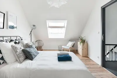 a white bedroom with a large bed and a chair at Flemishome, The Retreat For Family And Friends in Halle