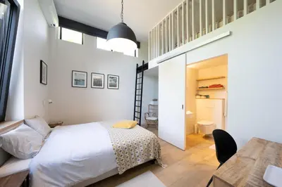 a bedroom with a bed and a dining room at B&B De Woestijn in Roosdaal