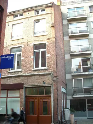 a building on a street with a person walking past it at Huize Rafael in Leuven