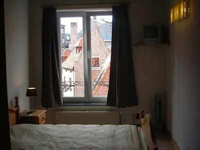a bedroom with a window with a view of a building at Huize Rafael in Leuven