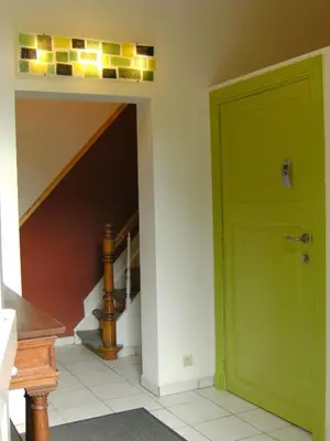 a hallway with a green door and stairs at Huize Rafael in Leuven