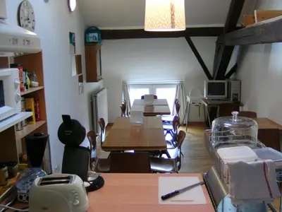 a dining room with a table and chairs and a kitchen at Huize Rafael in Leuven