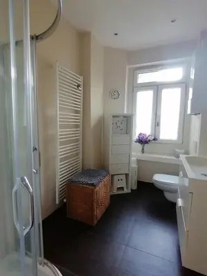 a bathroom with a toilet and a sink and a window at Brugmann Loft Apartment in Brussels