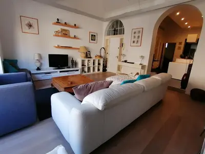 a living room with a white couch and a table at Brugmann Loft Apartment in Brussels