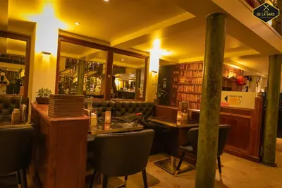 a restaurant with a table and chairs and a bar at Hotel Malon in Leuven
