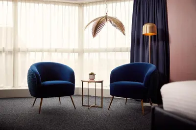 two blue chairs in a room with a window at Van der Valk Hotel Brussels Airport in Diegem