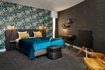 a bedroom with a blue bed and a tv at Van der Valk Hotel Brussels Airport in Diegem