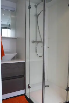 a glass shower in a bathroom with a sink at Drabstraat 2 Apartment in Ghent