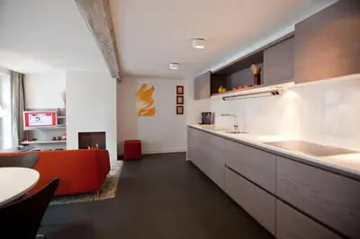 a kitchen with an orange couch and a table at Drabstraat 2 Apartment in Ghent