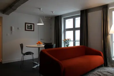 a living room with an orange couch and a table at Drabstraat 2 Apartment in Ghent