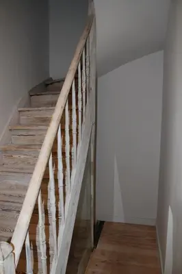 a wooden staircase in a room with white walls at Drabstraat 2 Apartment in Ghent