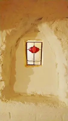 a window in a wall with a red flower on it at Romantic 16th century workers house in Ghent
