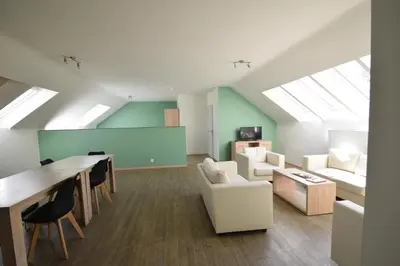 a living room with a couch and a table and chairs at Budget Flats Brussels in Brussels