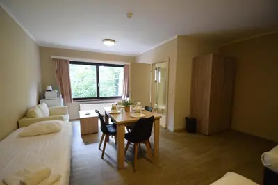 a room with a bed and a table with chairs at Budget Flats Brussels in Brussels