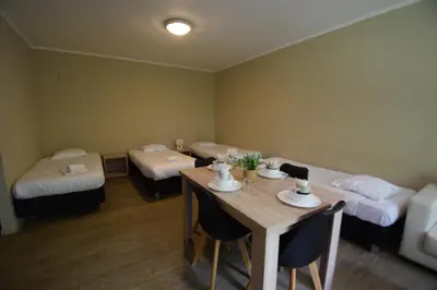 a room with two beds and a table with chairs at Budget Flats Brussels in Brussels