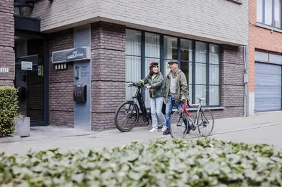 two people standing with their bikes outside of a building at Hotel Verlooy in Geel