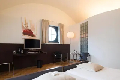 a hotel room with a bed and a tv at Hotel Verlooy in Geel