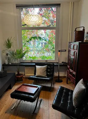 a living room with a couch and a large window at La bellétage by Agelandkaai be with Free Parking in Ghent
