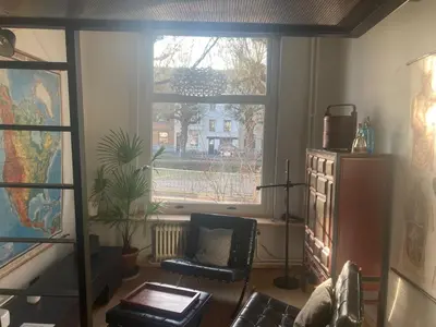 a living room with a chair and a window at La bellétage by Agelandkaai be with Free Parking in Ghent
