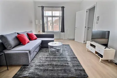 a living room with a couch and a tv at Rent a Flat - Bruxelles in Brussels