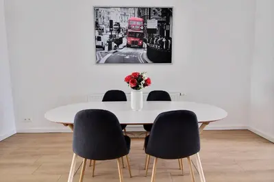 a white dining room table with chairs and a red bus at Rent a Flat - Bruxelles in Brussels