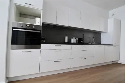 a kitchen with white cabinets and a black oven at Rent a Flat - Bruxelles in Brussels